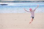 Girl running on beach, Daymer Bay, Cornwall, England, UK