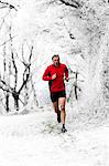 Man running through woods in winter, Wenlock Edge, Shropshire, England, UK
