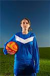 Portrait of female footballer holding ball