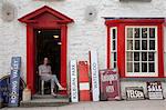 Woman sitting in antique shop doorway