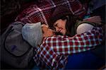 Mature couple lying down, hugging on picnic rug