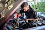 Mechanic working on car with bonnet open