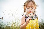 Portrait of female toddler with dandelion clock