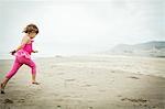 Female toddler running on beach