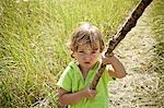 Portrait of female toddler holding long stick