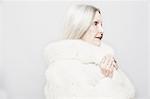 Studio portrait of senior woman in white fur coat