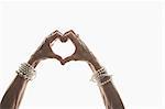 Studio shot of mature woman's hands making heart shape