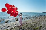 Mature woman pulling bunch of balloons