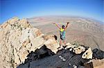 Female hiker celebrating on ridge, Mount Wilson, Red Rock Canyon, Nevada, USA