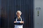 Portrait of female factory worker, arms folded