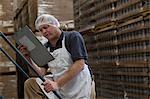 Man holding clipboard in warehouse