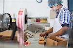 Man packaging vegan cheese in warehouse