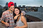 Young couple having fun at rooftop barbecue