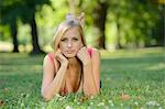 Young blond woman lying in a park