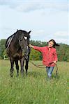 Girl standing with an Arabian Haflinger on a meadow