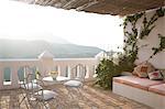 Table and chairs on balcony overlooking mountains