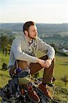 Man sitting on a rock with climbing equipment