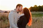 Couple kissing on field in autumn