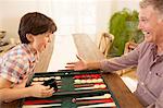 Grandfather and grandson playing backgammon