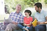 Multi-generation men laughing on bench