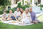 Multi-generation family enjoying picnic in backyard