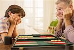 Grandfather and grandson playing backgammon