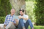 Father and son using digital tablet outdoors