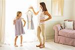 Mother and daughter picking out clothes in bedroom