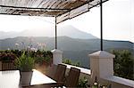 Table and chairs on balcony overlooking mountains