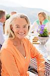 Senior woman smiling at patio table