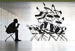 Businessman viewing office chair installation art