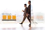 Businessmen walking in airport corridor