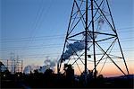 Silhouette of power lines and pylons at sunrise