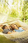 Couple relaxing in hammock outdoors