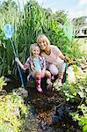 Woman and granddaughter fishing in pond