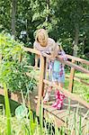 Grandmother and granddaughter fishing on wooden footbridge