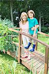 Grandmother and grandson smiling on wooden footbridge