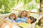 Mother and children relaxing together in hammock