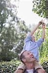 Father carrying son on shoulders outdoors