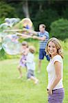 Family playing with bubbles in backyard