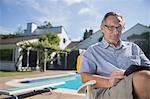 Man using digital tablet at poolside