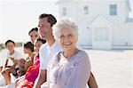 Multi-generation family smiling outside beach house