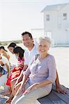 Multi-generation family smiling outside beach house