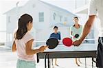 Family playing table tennis together outdoors