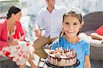 Girl with birthday cake licking lips