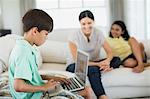 Boy using laptop on sofa in living room