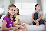 Girl using digital tablet on sofa in living room