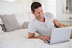 Man using laptop on bed