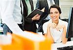 Businesswoman smiling at computer in office