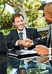 Businessmen shaking hands outdoors